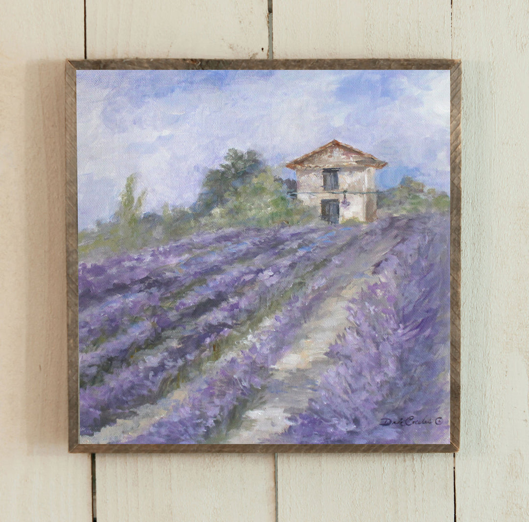 Lavender fields in full bloom on a French countryside farm, Shabby Chic and vintage rustic farmhouse and impressionistic by design. Lots of purples, tans, and blue sky with a few clouds. Green trees add to the warm feeling. By artist Debi Coules