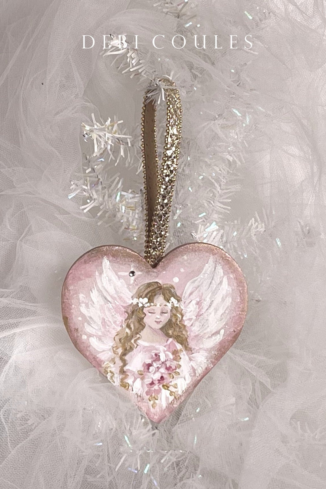 Heart-shaped wood ornament with a blond angel holding a bouquet of pink roses