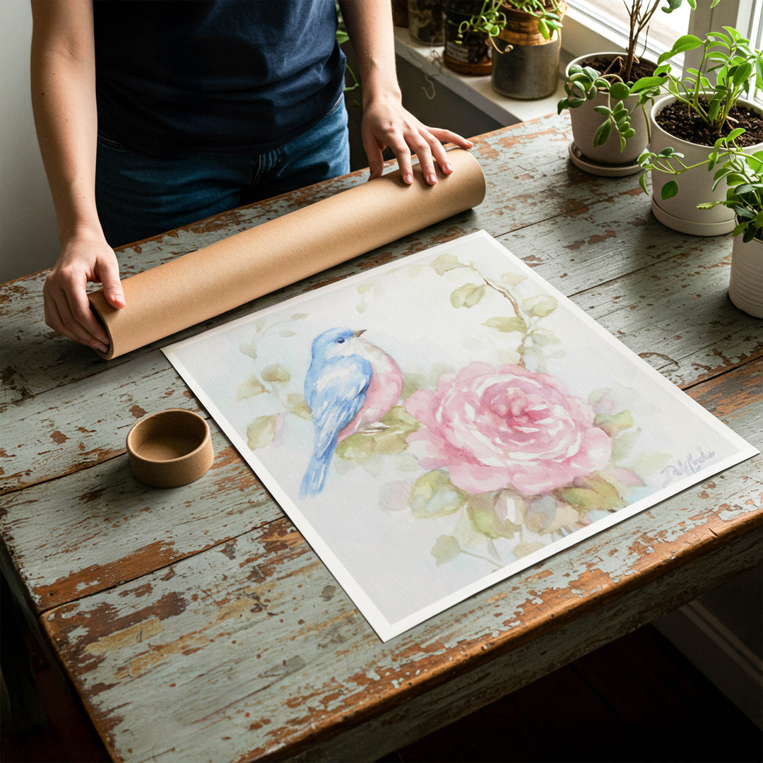 Person rolling up a fine-art paper print of shabby chic bluebird artwork to be placed in a cardboard mailing tube