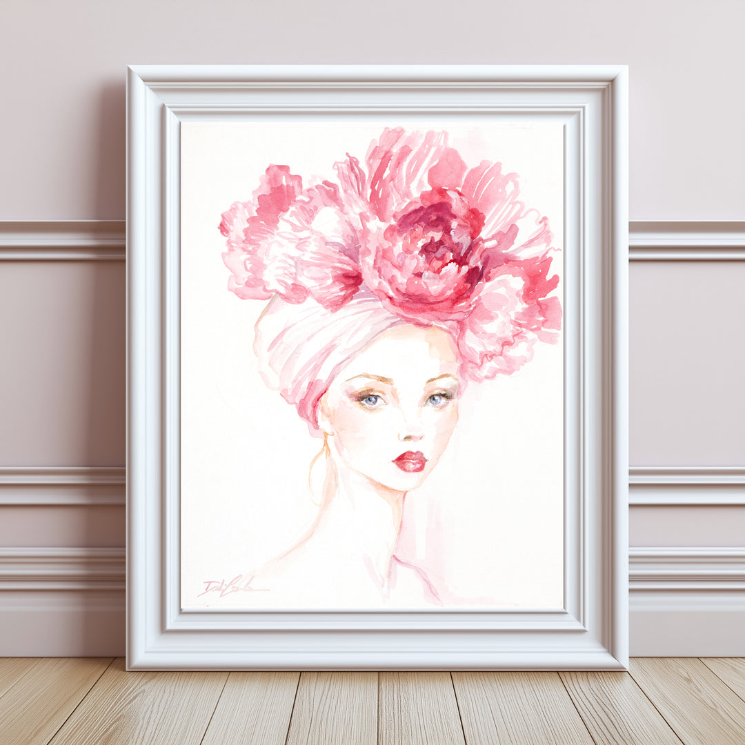 Framed artwork of a woman with a large pink flower on her head against a white wall.