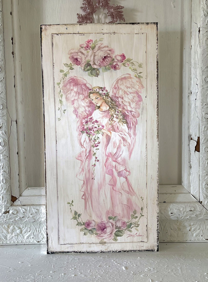 A beautiful shabby-chic painting of a pink angel holding a bouquet of roses.