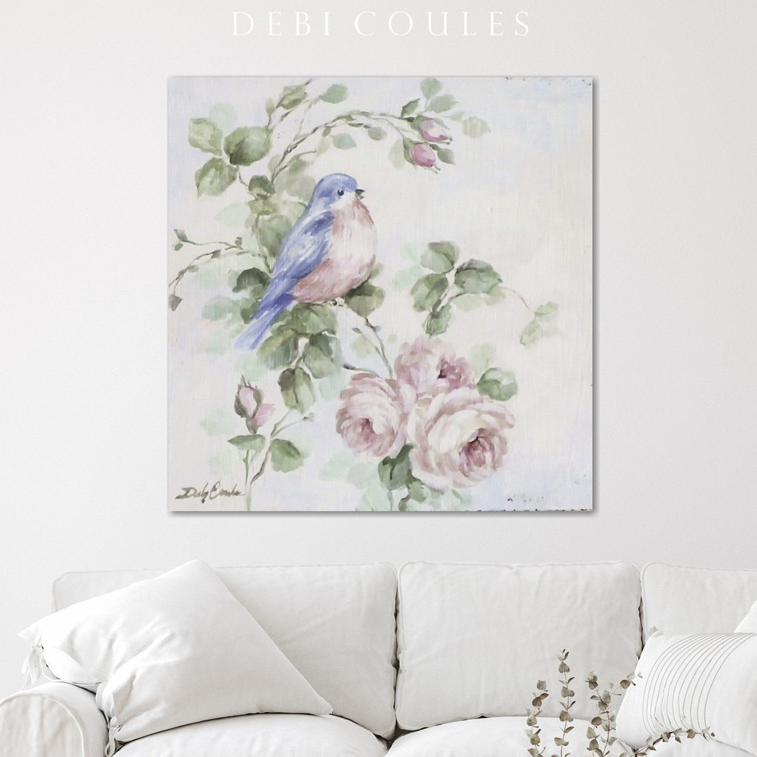 Shabby-chic canvas print of a singing bluebird hanging above a white couch