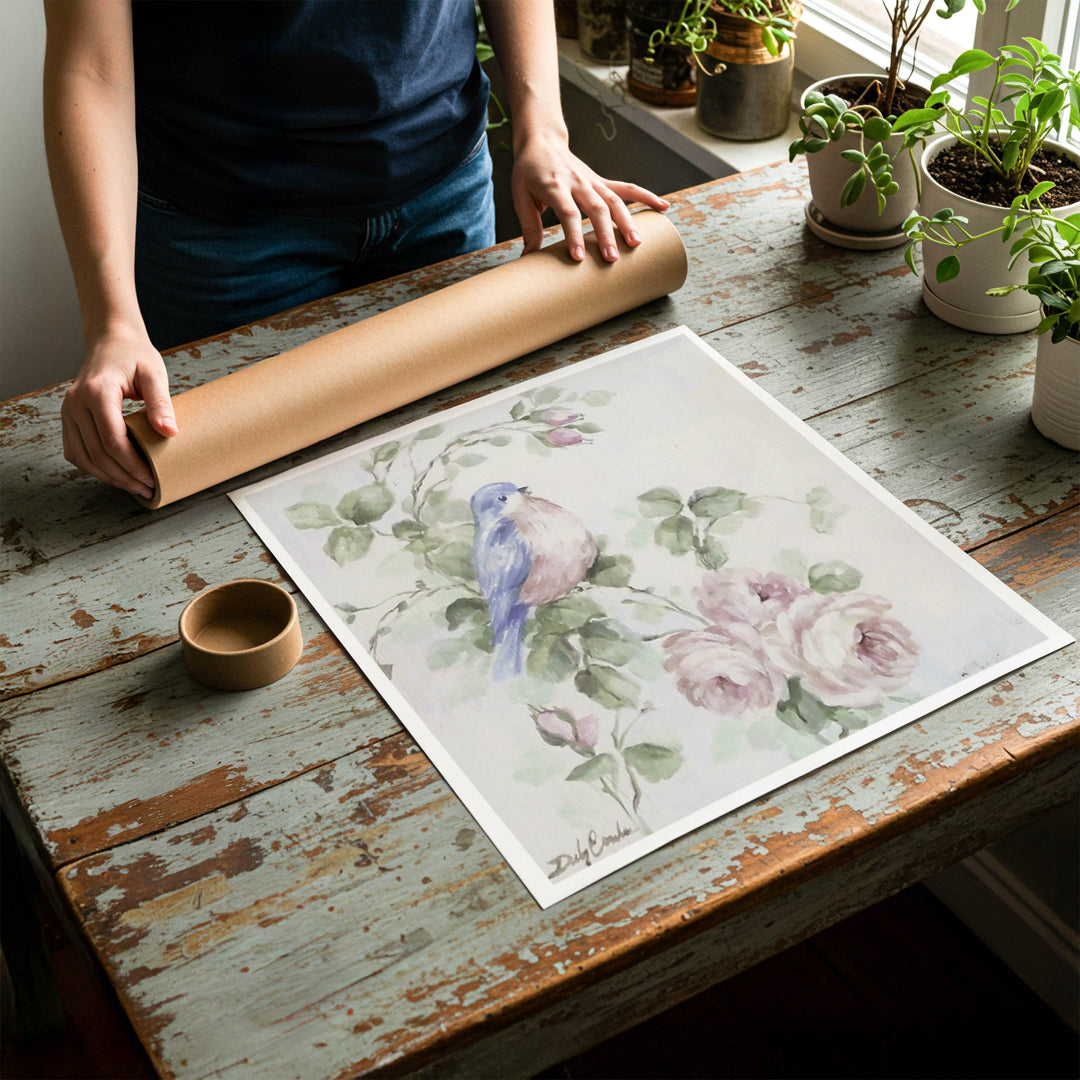 Person rolling up a fine-art paper print of shabby chic bluebird artwork to be placed in a cardboard mailing tube