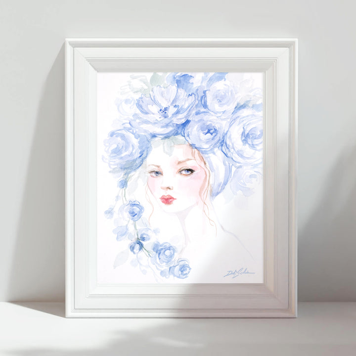 Framed artwork of a woman's face with blue floral hair on a white background