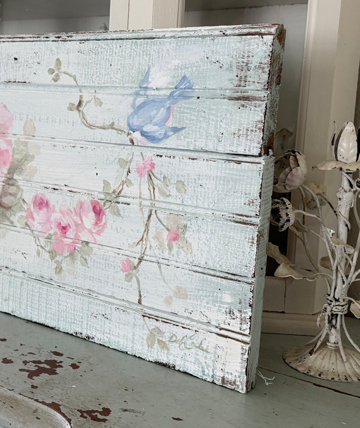 Side view of hand painted bluebird and pink roses on an original antique beadboard by Debi Coules, showing weathered reclaimed wood.