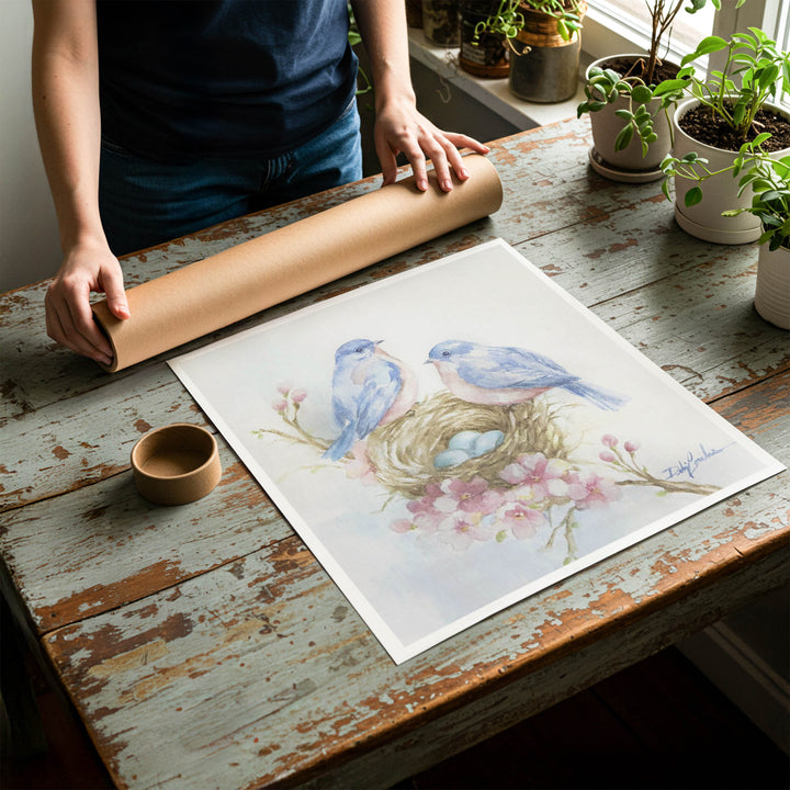 Person rolling up a fine-art paper print of shabby chic bluebird artwork to be placed in a cardboard mailing tube