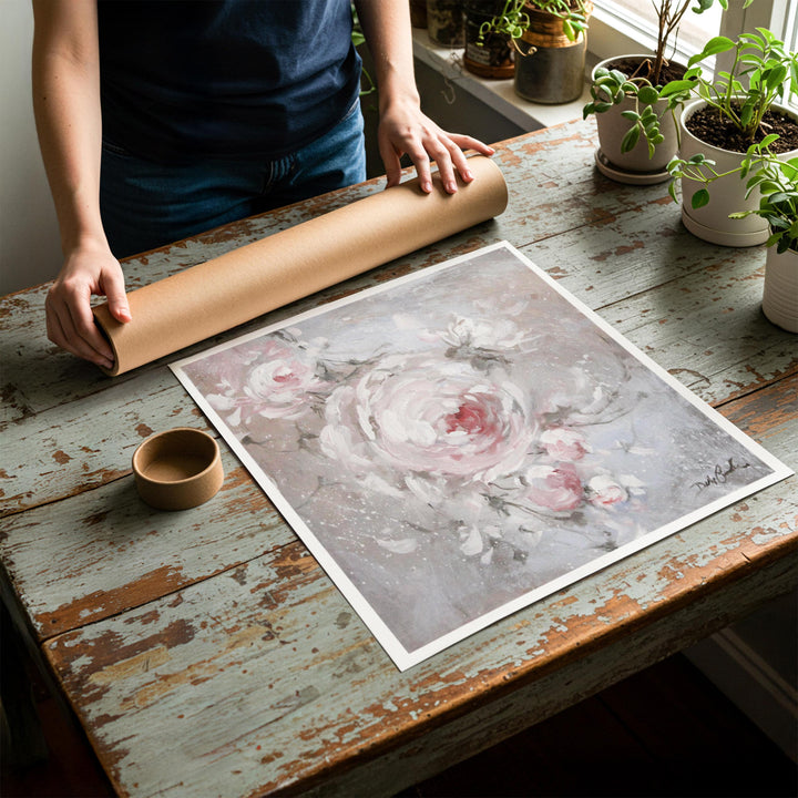 Person rolling up an unstretched canvas print of shabby chic rose artwork to be placed in a cardboard mailing tube