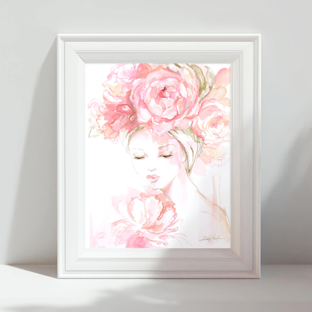 Framed artwork of a woman's face with pink flowers on a white background
