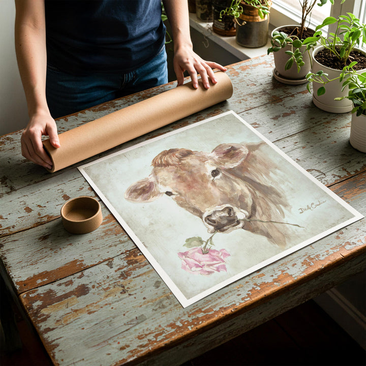 Person rolling up an unstretched canvas print of shabby chic cow artwork to be placed in a cardboard mailing tube