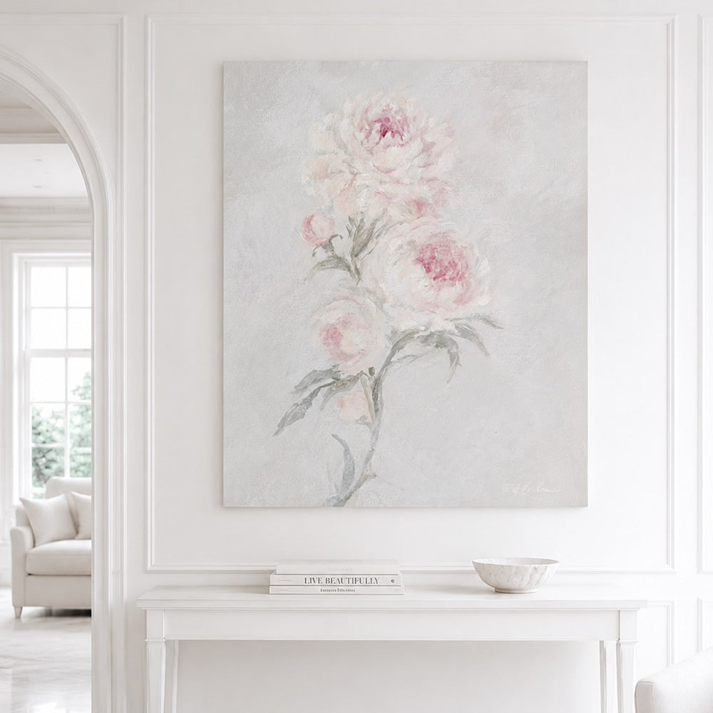 White and blush pink rose artwork hanging on a wall in a bright living room