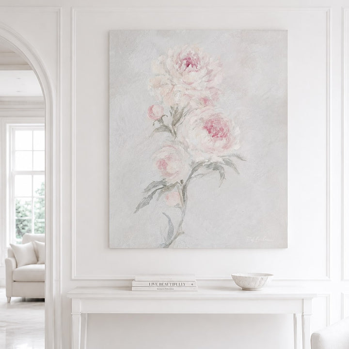 White and blush pink rose artwork hanging on a wall in a bright living room