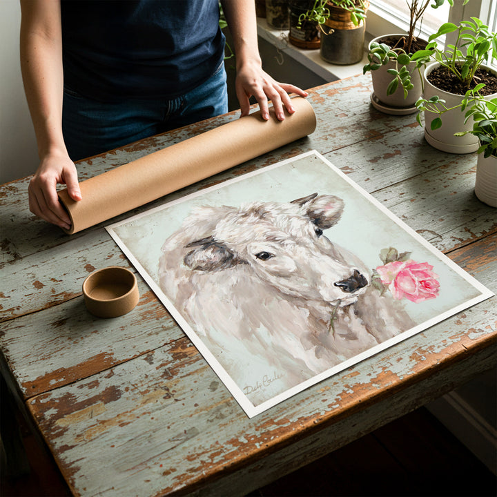 Person rolling up an unstretched canvas print of shabby chic cow artwork to be placed in a cardboard mailing tube