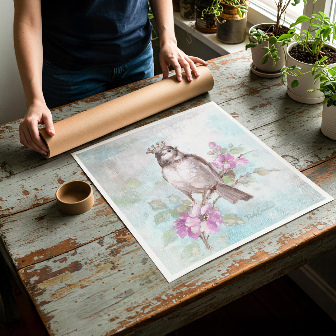 Person rolling up an unstretched canvas print of shabby chic crowned songbird artwork to be placed in a cardboard mailing tube