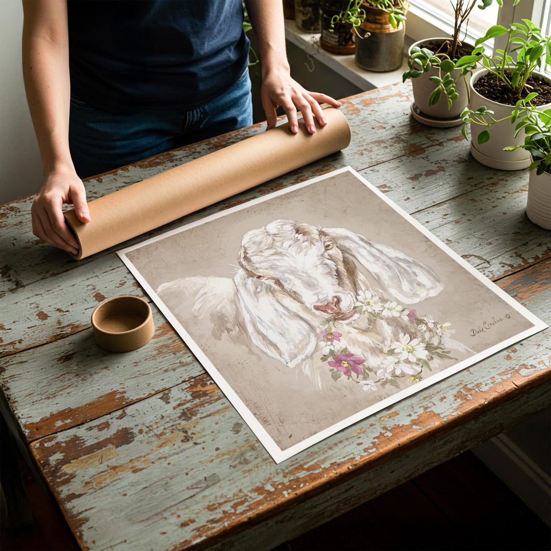 Person rolling up an unstretched canvas print of shabby chic goat artwork to be placed in a cardboard mailing tube
