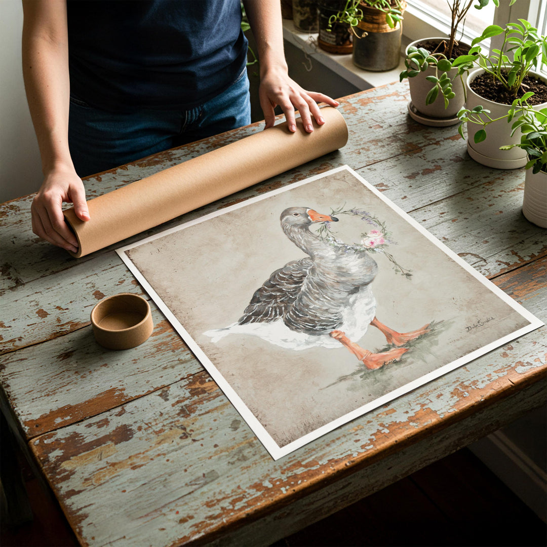 Person rolling up an unstretched canvas print of shabby chic goose artwork to be placed in a cardboard mailing tube