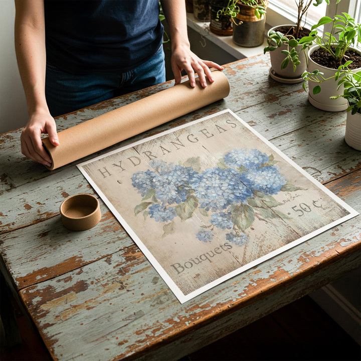 Person rolling up an unstretched canvas print of shabby chichydrangea artwork to be placed in a cardboard mailing tube