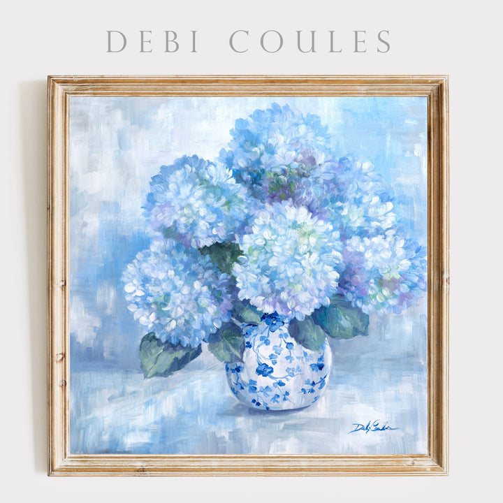 Framed paper print of blue hydrangeas in a vase by Debi Coules on a light background.