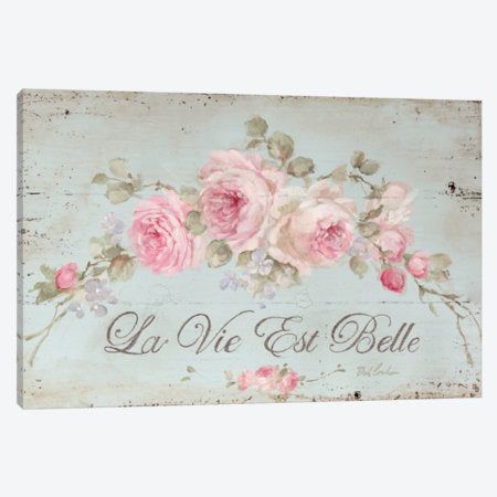 Decorative wall art with pink roses and 'La Vie Est Belle' text on a light blue background.