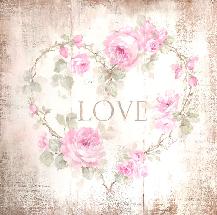 Shabby chic cottage sign with the word LOVE surrounded be roses with their stems twisted into a heart.