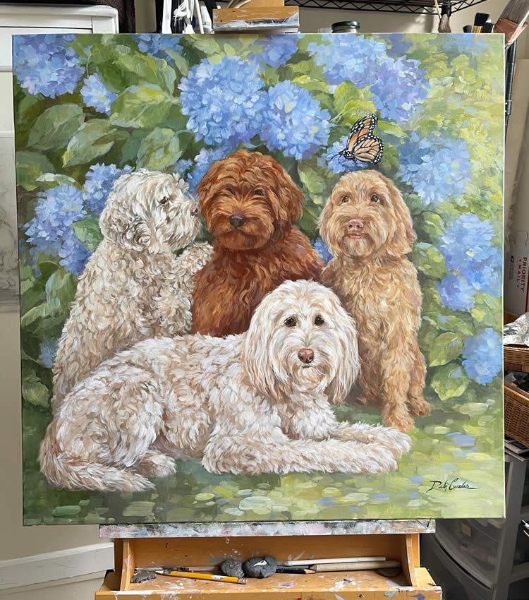 Group of four dogs in front of blue hydrangeas in a pet portrait