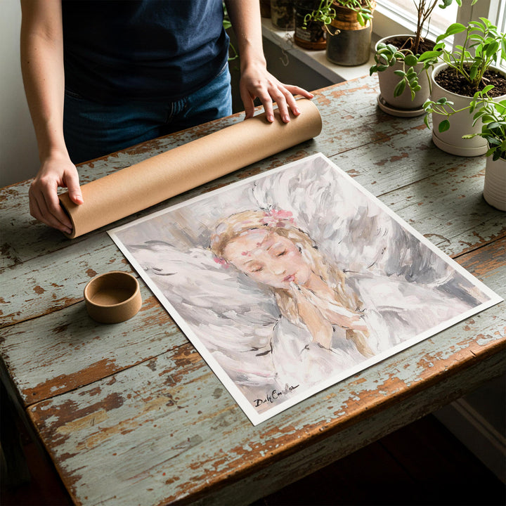 Person rolling up an unstretched canvas print of shabby chic angel artwork to be placed in a cardboard mailing tube