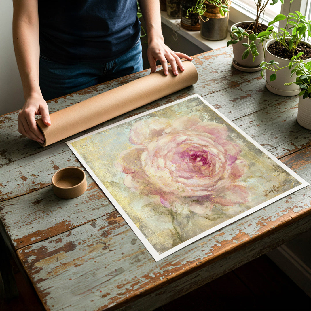 Person rolling up an unstretched canvas print of shabby chic rose artwork to be placed in a cardboard mailing tube