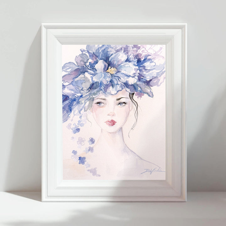 Framed artwork of a woman's face with a large blue floral headpiece 