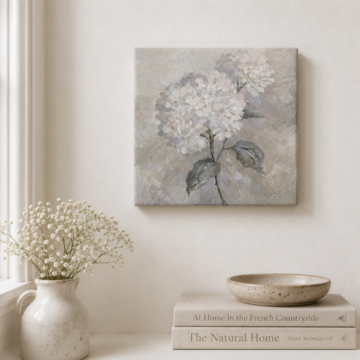Decorative scene with hydrangea floral painting on the wall, vase, books, and bowl on a shelf. Hydrangeas are white but painted in a muted color style.