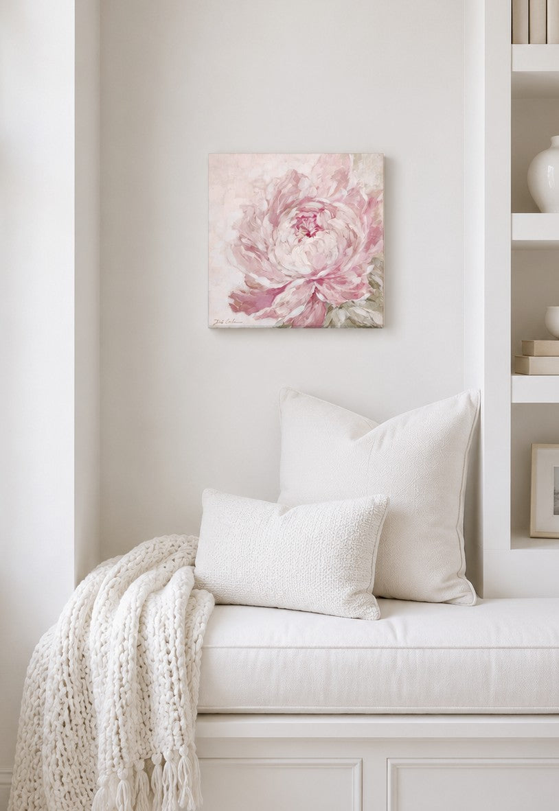Floral painting above a white bench with pillows and a blanket in a room setting.