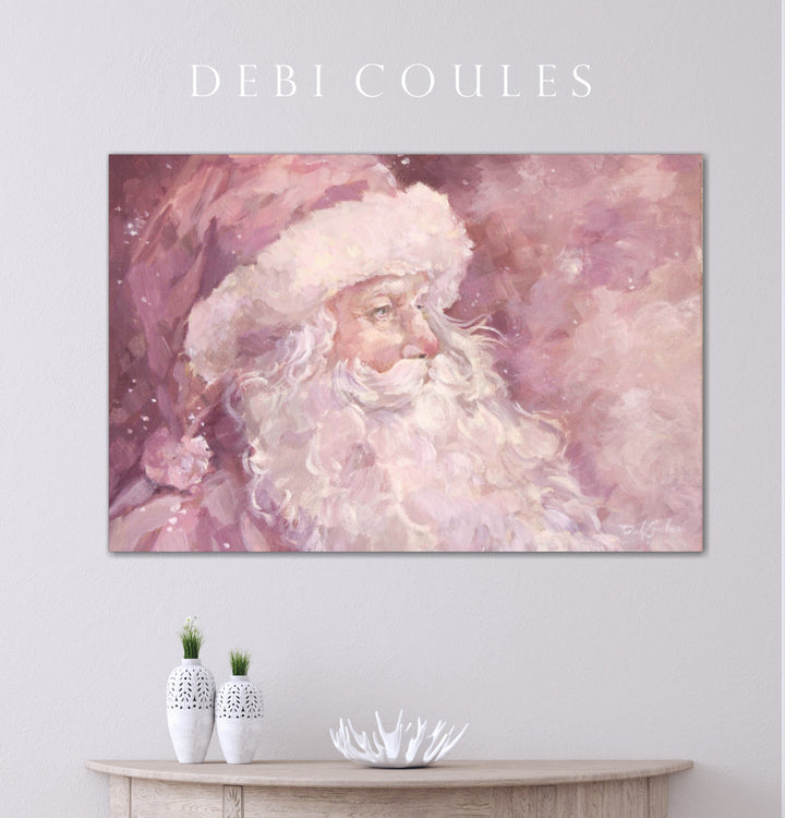 A holiday canvas  print of a stylized Pink Santa Claus on a wall above a wooden console table.
