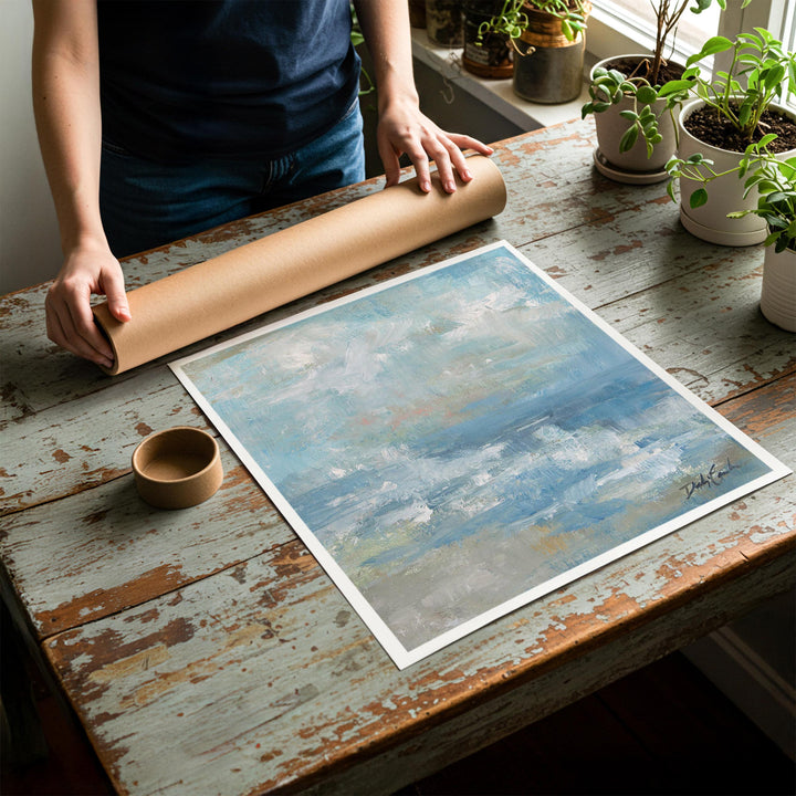 Person rolling up an unstretched canvas print of shabby chic beach artwork to be placed in a cardboard mailing tube