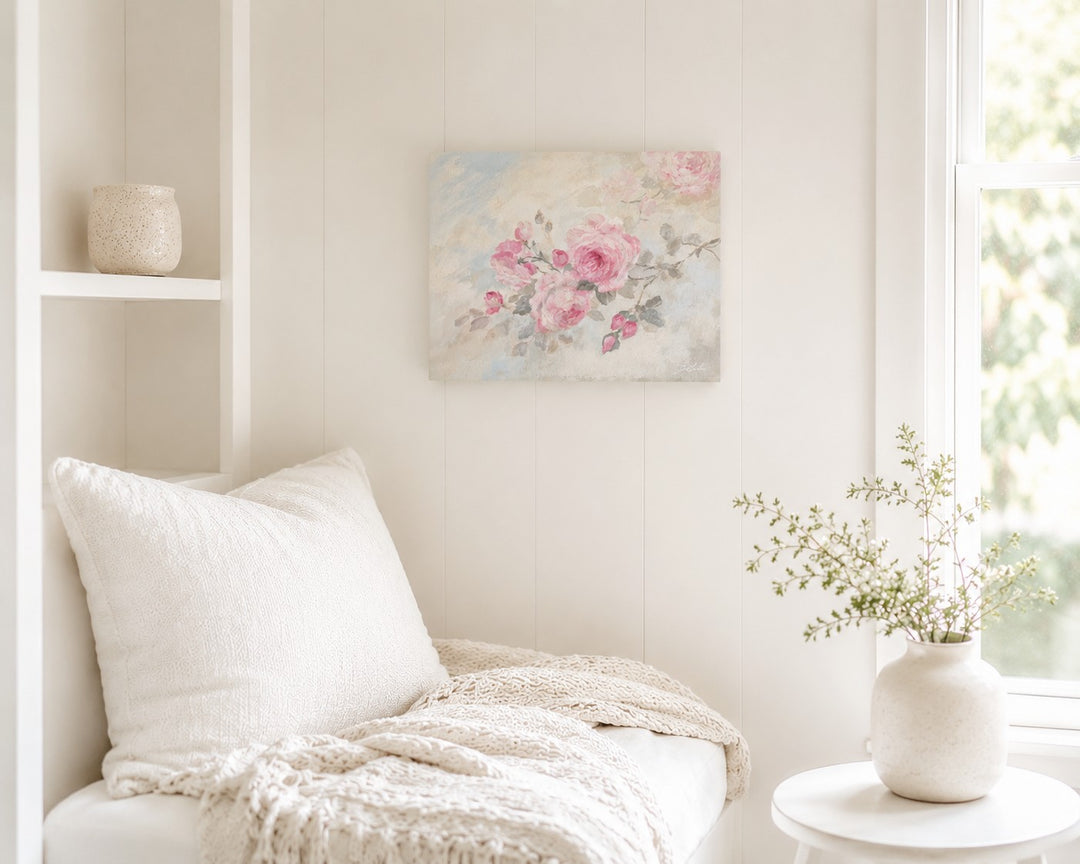 Cozy living room with a beautiful cottage core rose painting on the wall above a white sofa and side table.