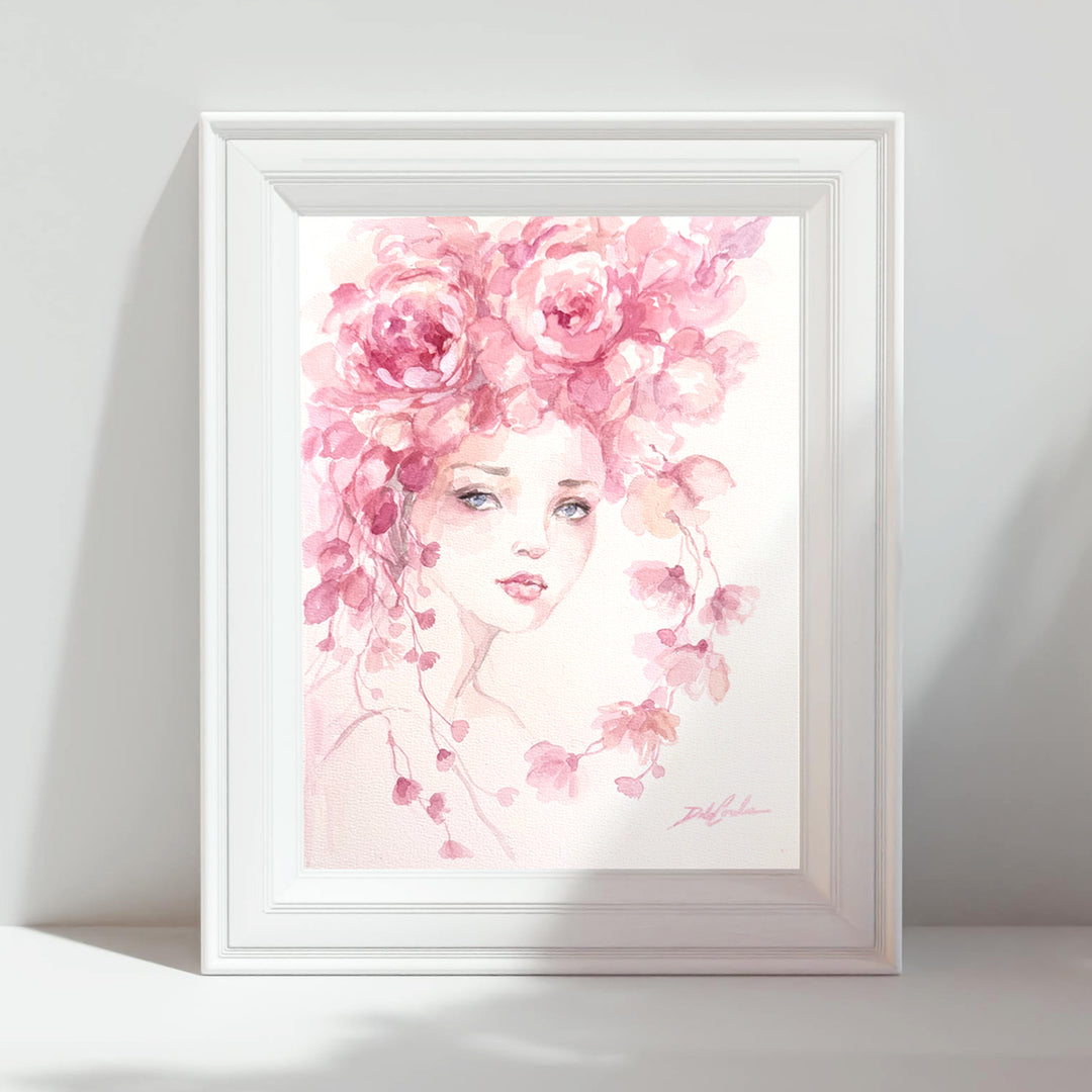 Framed artwork of a woman's face with pink floral elements on a white background