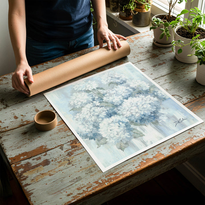Person rolling up a fine-art paper print of shabby chic hydrangea artwork to be placed in a cardboard mailing tube