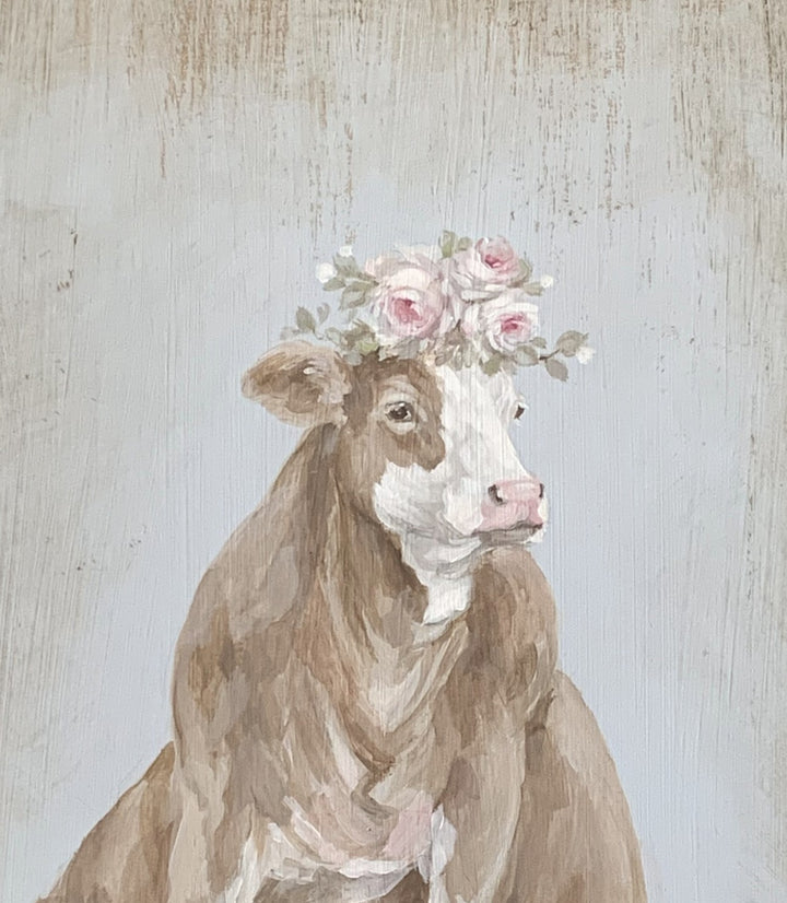 A Beautiful Tan Cow lounging in a vintage bathtub is sure to make you smile. She has a floral crown hightlighted with pink roses. , various shades of pink, off pink, mauve, whites on a blue grey background. Lots of shabby chic, modern farmhouse, and cottage warmth. Fabulous art by Debi Coules