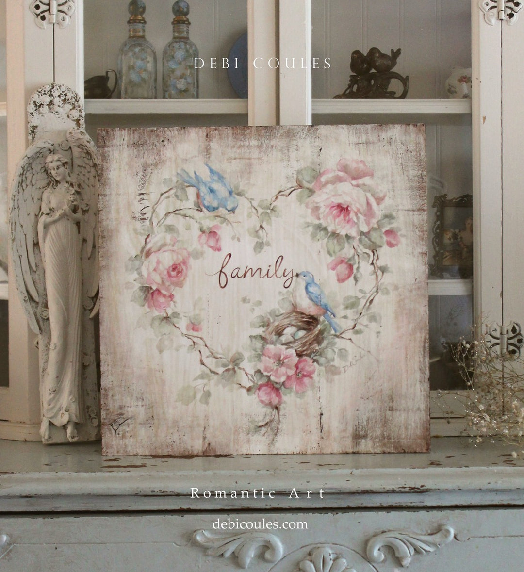 A beautiful heart of intertwined rose branches adorned with English and wild roses. Two bluebirds with nest surrounding a grand message of Family. Roses are pink on a antique white background. Would look with shabby chic or modern farmhouse decor.