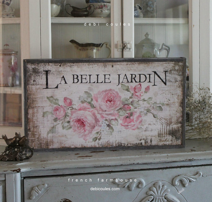 "The beautiful garden" La Belle Jardin. A canvas version of one of our signs. Pink roses on a background of off white and browns. Distressing all around. Printed on wood, framed in wood.  by Debi Coules