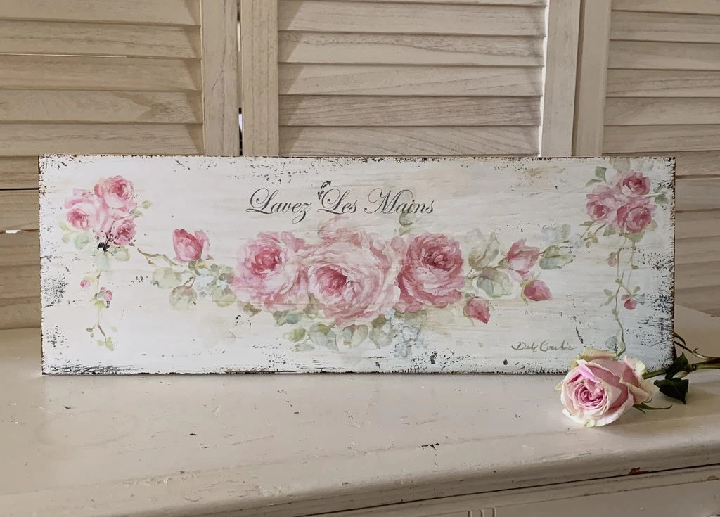 Off white background with lots of distressing. A swag of pink roses with leaves and buds create a wonderful backdrop for the slogan "Lavez les Mains" wash your hands! Perfect for your shabby chic, or french chic decorated bathroom,
