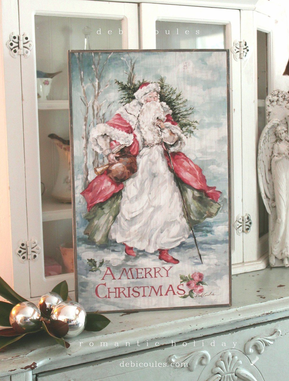 A wonderful Christmas painting, "North Woods Santa" by Debi Coules features a vintage-style Santa Claus arriving Christmas morning through the snow. This Holiday wood Print captures the feel of the long past Christmas Season.Vintage Santa Painting for a Rustic Christmas Home Decor. Printed on wood and framed with barnwood.