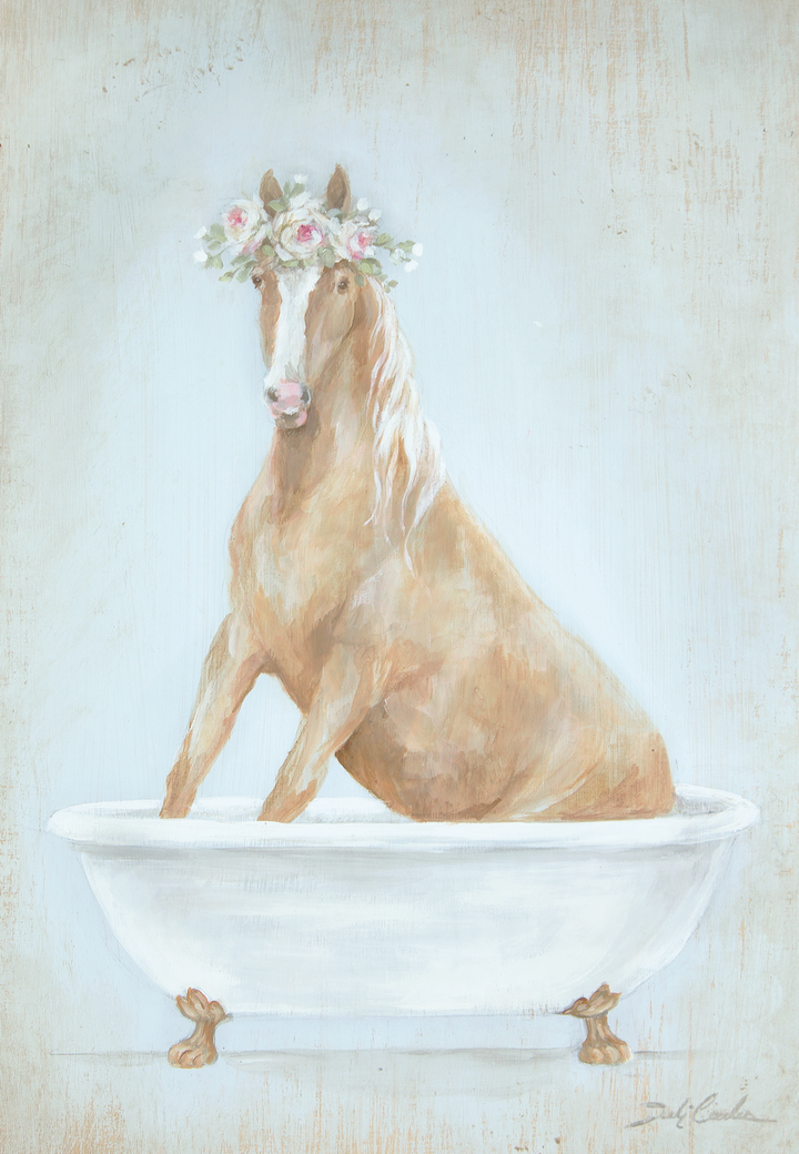 Tan horse with a crown of pink roses sitting in an antique bathtub. Background is light blue with distressing. Painted on wood by Debi Coules